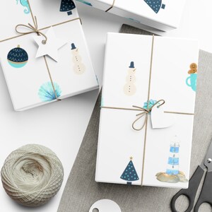 May include: Three white gift boxes with blue and green watercolor designs. The boxes are wrapped with twine and have white gift tags. The designs include a snowman, a Christmas tree, a seashell, a lighthouse, and a gingerbread man.