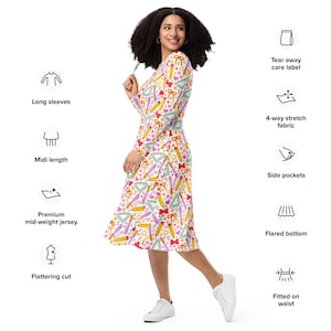 May include: A white midi dress with a colorful pattern of pencils, rulers, protractors, and bows. The dress has long sleeves, a flattering cut, and a flared bottom. It is made of a premium mid-weight jersey fabric and has side pockets.