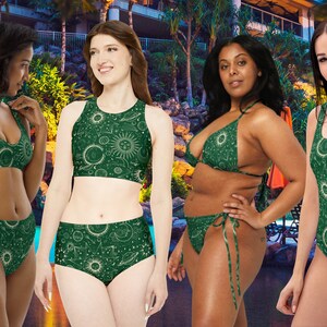 May include: Four women wearing different styles of green swimsuits with a celestial print. The print features white outlines of moons, stars, planets, and suns on a dark green background.