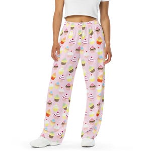 Könnte beinhalten: Rosa Schlafanzughose mit Cupcake-Muster. Die Cupcakes sind in verschiedenen Farben und Designs.