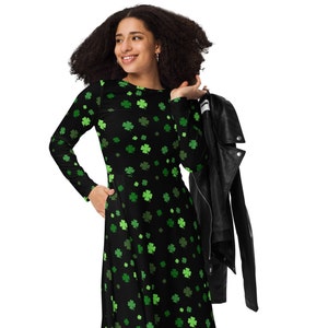 May include: A black long-sleeved dress with a green shamrock print. The dress has a round neckline and a flared skirt. The model is wearing a black leather jacket.