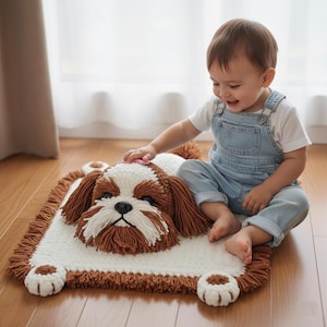 Pode incluir: Tapete de cão de crochê feito à mão em marrom, branco e bege. O tapete apresenta um rosto de cão detalhado com orelhas caídas e detalhes em forma de pata. O tapete é retangular com uma borda com franjas.