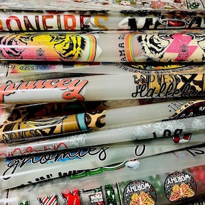 May include: A stack of clear vinyl sheets with various colorful designs printed on them. The designs include text such as "Confident", "Blessed", "Hallelujah", and "Gnomes". There are also images of tigers, butterflies, and other patterns.