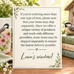 May include: A rectangular white sign with a black border and floral accents in the corners. The text reads: If you're ordering more than one type of item, please note that your items may ship separately. Luna's window! with a small heart icon.