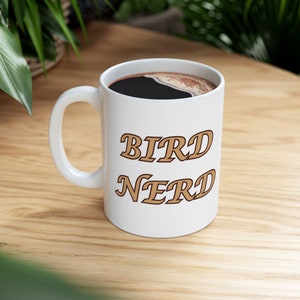 11 oz Ceramic Coffee Mug with "Bird Nerd" text on one side, and a Carolina wren illustration on the other.