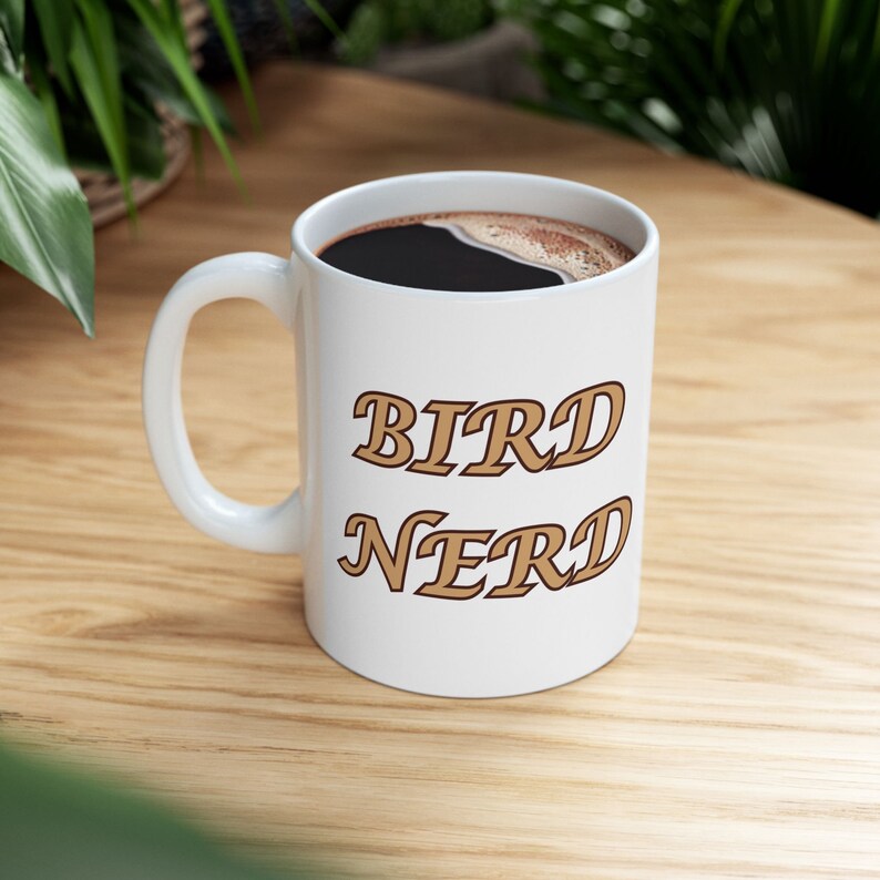 11 oz Ceramic Coffee Mug with "Bird Nerd" text on one side, and a Carolina wren illustration on the other.