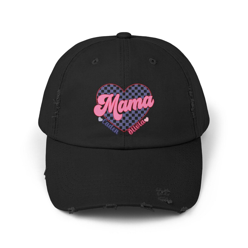 May include: Black distressed baseball cap with a pink and blue checkered heart design. The heart has the word "Mama" in pink letters and the names "Caden" and "Olivia" in smaller letters below.