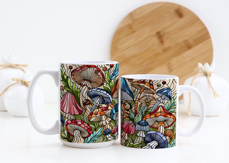 K&ouml;nnte beinhalten: Zwei wei&szlig;e Keramikbecher mit einem bunten Pilzdesign. Die Becher stehen auf einer wei&szlig;en Oberfl&auml;che mit einem Holzbrett im Hintergrund.