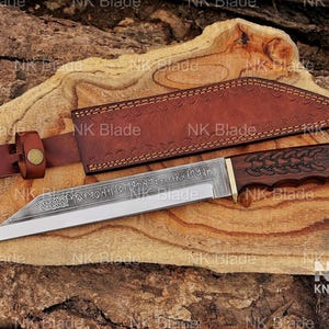 May include: A fixed-blade knife with a dark wood handle featuring carved knotwork patterns and a steel blade etched with runic inscriptions and Celtic designs. The knife includes a brown leather sheath with a belt loop and a brass-colored metal rivet.