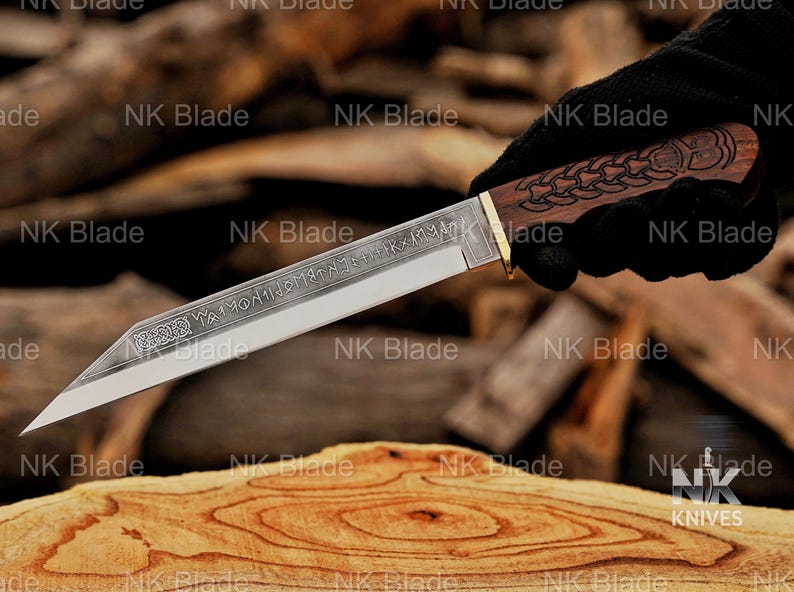 May include: A fixed-blade knife with a silver-toned steel blade featuring etched runic inscriptions and a decorative knotwork pattern near the hilt. The handle is crafted from dark brown wood with an intricate carved design and a brass-colored bolster.