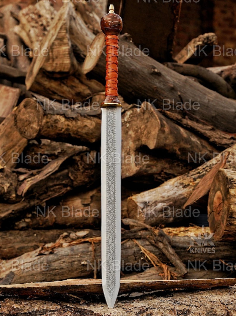 May include: A double-edged sword featuring a silver-toned blade with an intricate etched pattern running down the center. The hilt consists of a brown leather-wrapped grip, a rounded wooden pommel with swirling grain, and a brass-colored guard.