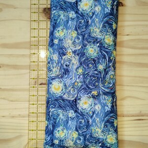 May include: A blue and yellow patterned fabric pillow with a design resembling Vincent van Gogh's "Starry Night".