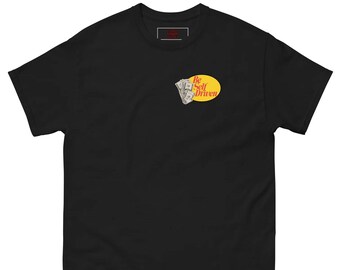 May include: Black t-shirt with a small graphic on the chest. The graphic features a stack of money and the words "Be Self Driven" in a yellow oval. The shirt has a classic crew neck and short sleeves.