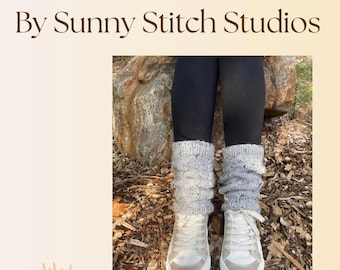 May include: Image of a pair of gray cable knit leg warmers over black leggings and white sneakers. The text at the top reads "Cozy Cable Leg Warmer Pattern By Sunny Stitch Studios". The leg warmers are scrunched down over the ankles.