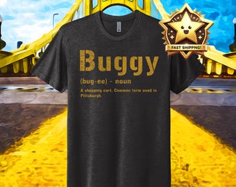 May include: A dark grey t-shirt with a gold graphic that says "Buggy (bug-ee) - noun A shopping cart. Common term used in Pittsburgh."