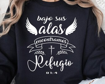 May include: Black sweatshirt with white text that reads "bajo sus alas encontramos refugio 91:4". The text is surrounded by a pair of wings, a cross, and a banner.