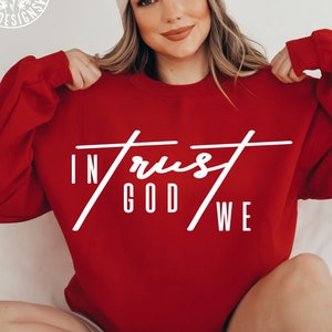 May include: Red sweatshirt with white text that reads "In God We Trust".