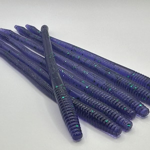 May include: A bundle of purple and green glitter worm fishing lures.
