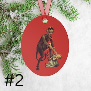 May include: Red round Christmas ornament with a vintage illustration of a devil pulling a young girl by her hair with a chain.