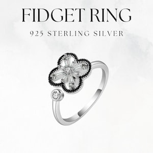 Op de afbeelding: Een zilveren ring met een zwart klaverblad ontwerp en heldere zirkonia stenen. De ring is gemaakt van 925 sterling zilver.
