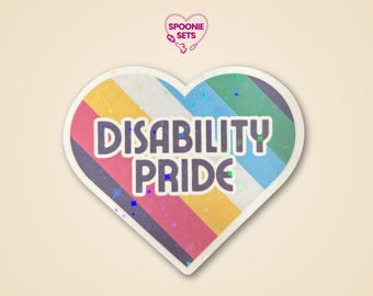 Puede incluir: Una pegatina en forma de corazón con un diseño de rayas arcoíris y las palabras "DISABILITY PRIDE" en negrita. La pegatina tiene un borde blanco y un efecto holográfico, con el logotipo de Spoonie Sets en la parte superior.
