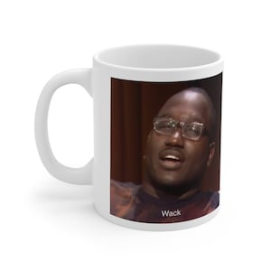 May include: White ceramic coffee mug with a photo of a person wearing glasses and a dark shirt. The text "Wack" is printed on the bottom of the mug.