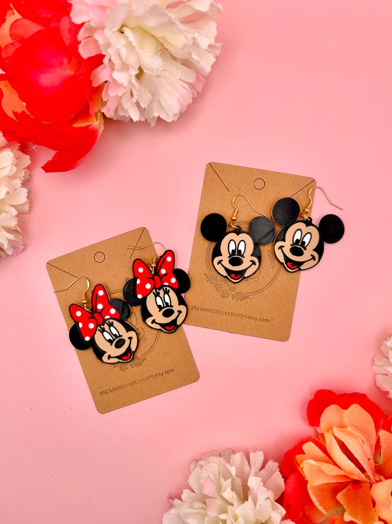 Mickey:
--- Width 1.6 inches
--- Length 1.4 inches
--- Drop length 2.0 inches

Minnie:
--- Width 1.4 inches
--- Length 1.7 inches
--- Drop length 2.2 inches