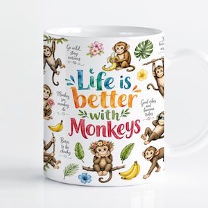 Può includere: Una tazza in ceramica bianca con una colorata illustrazione ad acquerello di varie scimmie, banane e foglie tropicali. Il testo recita Life is better with Monkeys, Go wild, stay curious, Monkey see, monkey do, Born to be cheeky e Good vibes.