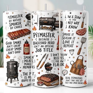 May include: A white cylindrical tumbler featuring a barbecue theme with illustrations of smokers, grills, ribs, brisket, BBQ sauce, and grilling tools. The design includes black text with phrases like Pitmaster by Nature and Low & Slow is the Only Way.
