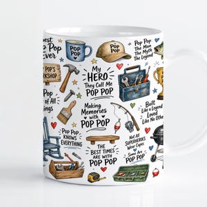 Op de afbeelding: Een witte keramische mok met een herhalend patroon van illustraties en tekst, waaronder een blauwe gereedschapskist, een hengel, een hamer, een schommelstoel, een barbecue en de tekst My Hero They Call Me Pop Pop.