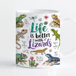 Könnte beinhalten: Ein weißer Keramikbecher mit farbenfrohen Aquarellillustrationen verschiedener Echsen, darunter ein Chamäleon und eine Bartagame, sowie kleinen Blumen- und Insektenmotiven. Der Text lautet: Life is better with Lizards, Stay curious, little one, Tiny feet, big adventures, Different is beautiful und Slow down and soak up the sunshine.