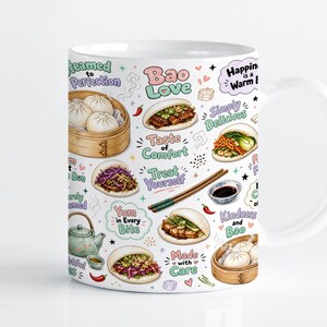 Op de afbeelding: Een witte keramische mok met een kleurrijk patroon van gestoomde bao-broodjes in bamboemandjes, diverse gevulde bao-sandwiches, een theepot, eetstokjes en een klein kommetje sojasaus, voorzien van teksten zoals Bao Love en Steamed to Perfection.