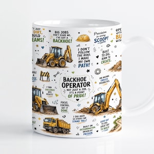 May include: A white ceramic mug featuring yellow backhoe construction vehicles, a dump truck, and various motivational phrases including Backhoe Operator, Not Just A Job, It's A Point Of Pride, Big Jobs Don't Scare Me, and Precision In Every Scoop.