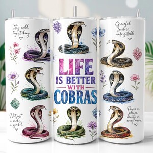 Op de afbeelding: Een witte cilindrische beker met meerdere kleurrijke cobra-illustraties, florale accenten en de tekst "LIFE IS BETTER WITH COBRAS" samen met zinnen als "Stay wild, stay striking," "Not just a snake, a symbol," en "Graceful, fearless, unforgettable."