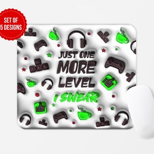 May include: A white mouse pad with a green and brown design. The mouse pad features a gamer-themed design with a video game controller, headphones, coffee cups, and the text "Just One More Level I Swear".