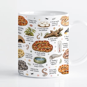 Puede incluir: Una taza de cerámica blanca con una guía ilustrada a color sobre el cuidado de serpientes. El diseño incluye varias especies de serpientes, huevos, un cuenco de agua, un termómetro y un trozo de madera, junto con instrucciones numeradas.