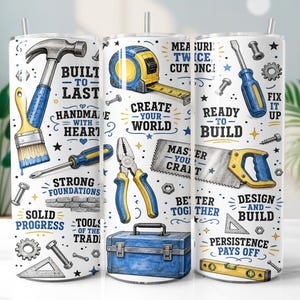 May include: A white cylindrical tumbler featuring a repeating pattern of blue and yellow construction tools including a hammer, tape measure, screwdriver, pliers, saw, and toolbox, interspersed with motivational text like Built to Last.