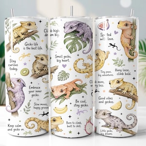 Puede incluir: Un vaso cilíndrico blanco con un patrón repetitivo de geckos coloridos, hojas tropicales, frutas y estrellas. El diseño incluye textos inspiradores como Gecko life is the best life, Small gecko, big heart y Born to climb, built to chill.