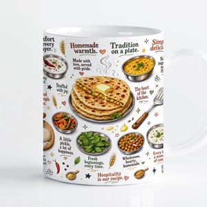 Puede incluir: Una taza de cerámica blanca con ilustraciones coloridas de panes planos indios, cuencos de curry, hierbas frescas y especias. El diseño incluye textos como Homemade warmth, Tradition on a plate y Hospitality is our recipe alrededor de la comida.