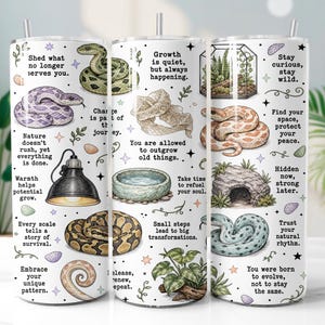 Op de afbeelding: Een witte cilindrische beker met diverse slangenillustraties, een terrarium, een warmtelamp, een waterbak en een rotsgrot. Het ontwerp bevat inspirerende teksten zoals Shed what no longer serves you, Growth is quiet en Stay curious, stay wild.