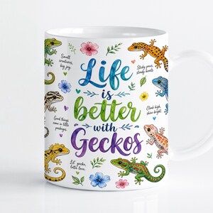 Op de afbeelding: Een witte keramische mok met een kleurrijke aquarelillustratie van diverse gekko's, kleine bloemen en bladeren. De tekst luidt: Life is better with Geckos, samen met zinnen zoals Small creatures, big joy, Sticky paws, steady hearts.