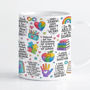 Könnte beinhalten: Ein weißer Keramikbecher mit einem bunten, vielseitigen Design, das verschiedene pädagogische und inklusive Zitate, Puzzleteil-Herzen, einen Regenbogen, einen Bücherstapel, ein Federmäppchen, einen Apfel und einen Handabdruck mit Herz zeigt.