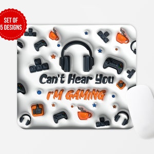 May include: A white gaming mouse pad with a black and orange design. The design features a pair of headphones, a video game controller, and the text "Can't Hear You I'm Gaming".