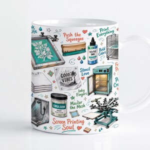 May include: A white ceramic mug featuring a colorful pattern of screen printing equipment including a squeegee, textile ink, a drying rack, a curing oven, and a printing press, with text phrases like Screen Printing Soul and Good Vibes.