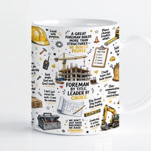 Könnte beinhalten: Ein weißer Keramikbecher mit einem Design zum Thema Bauwesen, das Illustrationen eines gelben Schutzhelms, Krans, Baggers, Werkzeugkastens und Bauplänen zeigt. Der Text lautet "A GREAT FOREMAN BUILDS MORE THAN STRUCTURES" und "FOREMAN BY TITLE, LEADER BY CHOICE."