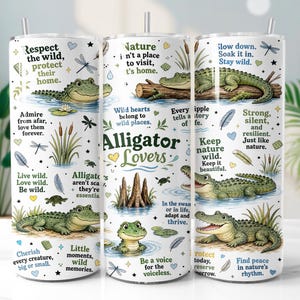 Op de afbeelding: Een witte cilindrische beker met metalen rietje, voorzien van groene alligatorillustraties, moerasvegetatie en inspirerende teksten zoals "Respect the wild", "Alligator Lovers" en "Slow down. Soak it in. Stay wild.".