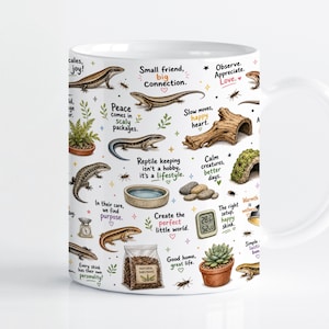 May include: A white ceramic mug featuring colourful illustrations of skinks, terrarium supplies, and plants. Text includes phrases like Small friend, big connection, Peace comes in scaly packages, and Reptile keeping isn't a hobby, it's a lifestyle.