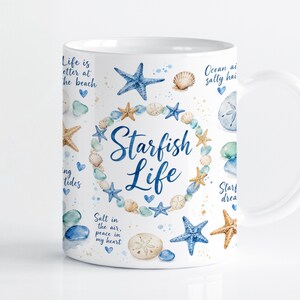 Puede incluir: Una taza de cerámica blanca con una corona central de conchas marinas y estrellas de mar azules en acuarela que rodea el texto Starfish Life. El diseño incluye estrellas de mar azules, dólares de arena y frases inspiradoras dispersas.