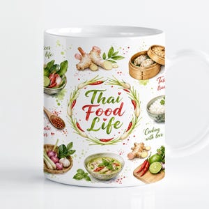 Könnte beinhalten: Ein weißer Keramikbecher mit einem farbenfrohen Aquarell-Druck thailändischer Zutaten wie Ingwer, Chilischoten, Limetten und Bambusdämpfern. Der zentrale Schriftzug lautet Thai Food Life, umgeben von einem Kranz aus grünen Kräutern und roten Chilis.