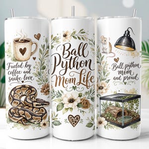 May include: Three white cylindrical tumblers with straws featuring floral designs, a ball python, a coffee mug with a heart, a mouse, a terrarium, and text reading Fueled by coffee and snake love, Ball Python Mom Life, and Ball python mom and proud.